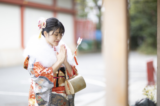 A woman dressed in traditional Japanese attire paying her first shrine visit of the year